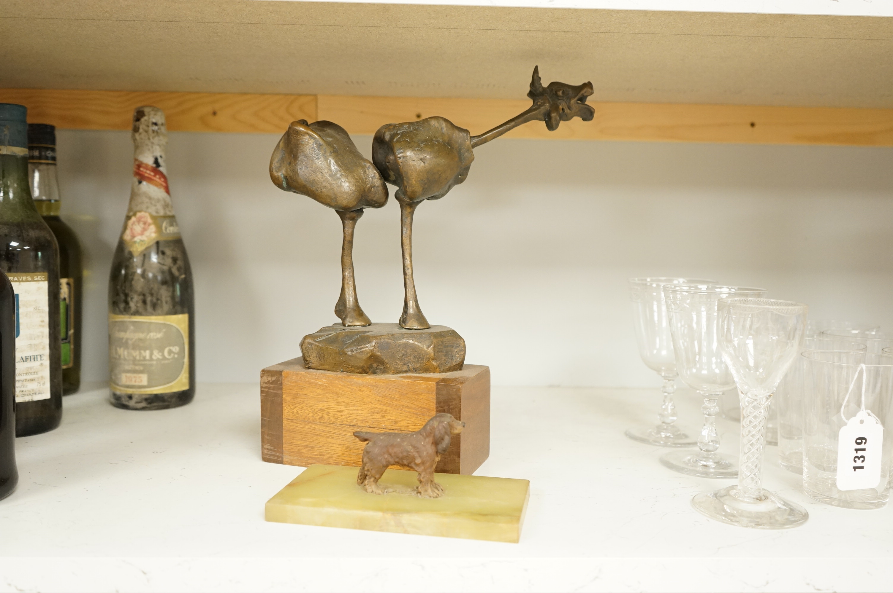 An abstract bronze model of a cow, 34cm and an Art Deco green onyx box, the lid surmounted with a cold painted bronze spaniel, 16.5cm wide.